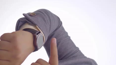 man tapping finger on wristwatch, close-up against white background