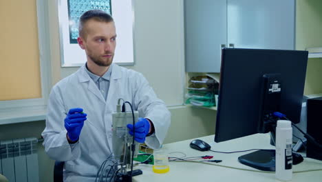 scientist works in modern lab. male research scientist sitting at workplace in laboratory