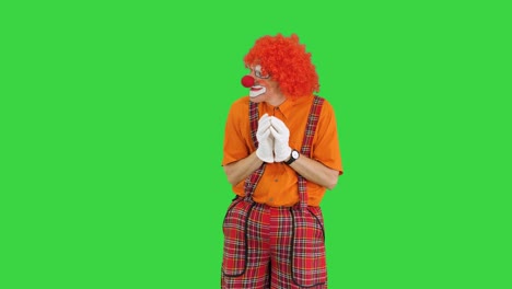 cunning clown thinking having some evil thoughts on a green screen, chroma key