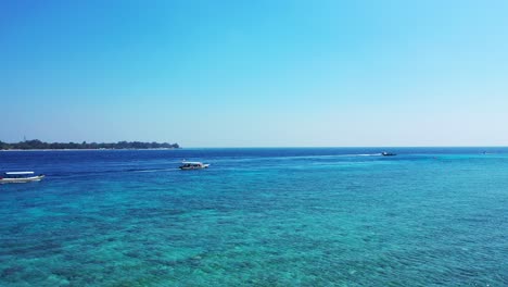 Touring-boats-leaving-from-shore-of-tropical-island-toward-open-blue-sea-with-tourists-on-board-to-visit-other-exotic-location-of-Thai-coastline