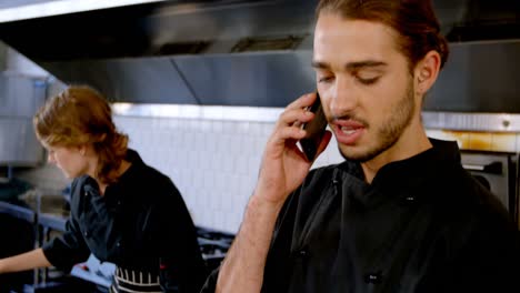 chef looking at clipboard while talking on mobile phone 4k