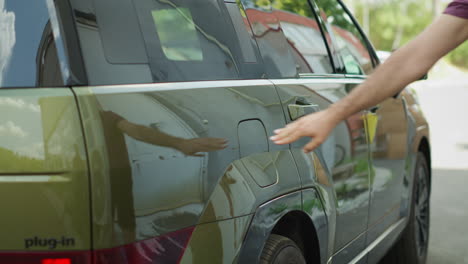 close up of man closing vehicle inlet of ev eco friendly suv car after charging