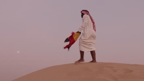 african american uganda flag in hand dressed as arab