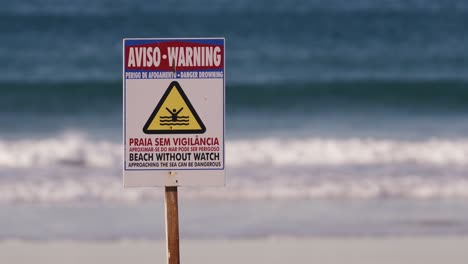 beach without watch warning sign, ocean or sea waves in background, portugal signboard