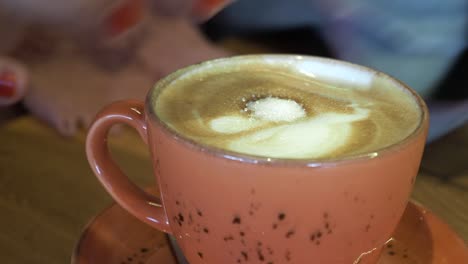 cappuccino in a coral colored cup