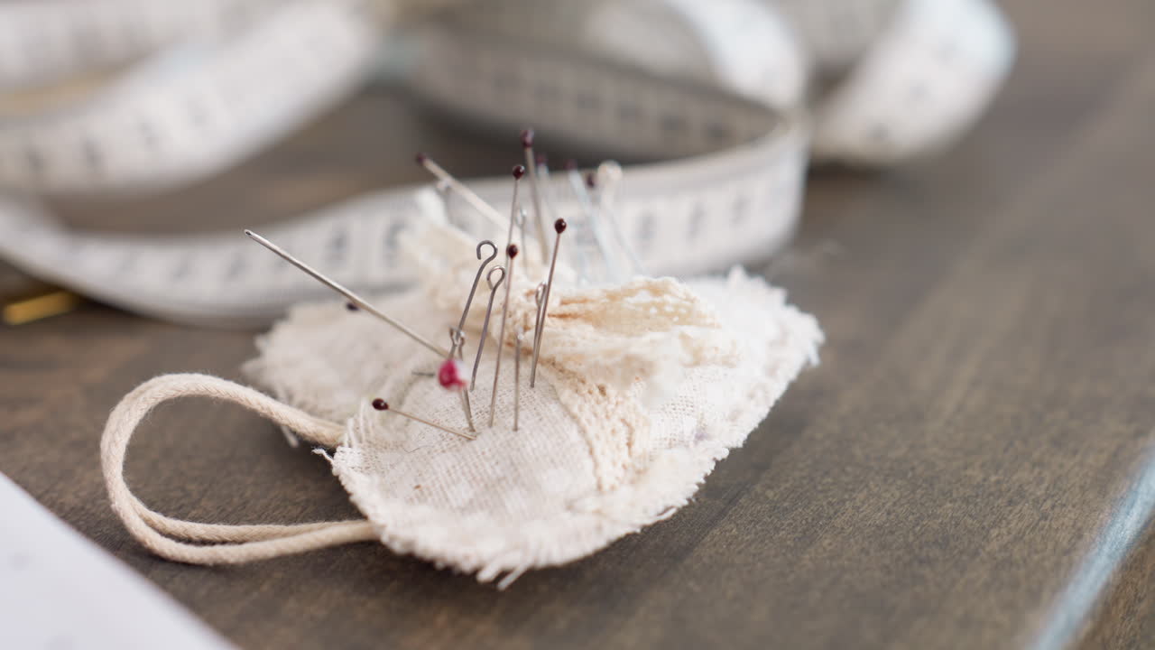 Close up of office pin stacked into form on table, used for sewing or garment creation, capturing detail, reflecting skillful craft, emphasizing delicate precision, background measuring tape