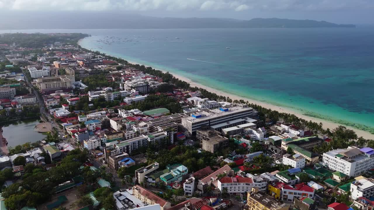 Uno splendido panorama aereo con drone dell'iconica White Beach dell'isola di Boracay, Filippine, con acque turchesi, sabbia bianca e infrastrutture turistiche fronte mare in una giornata limpida