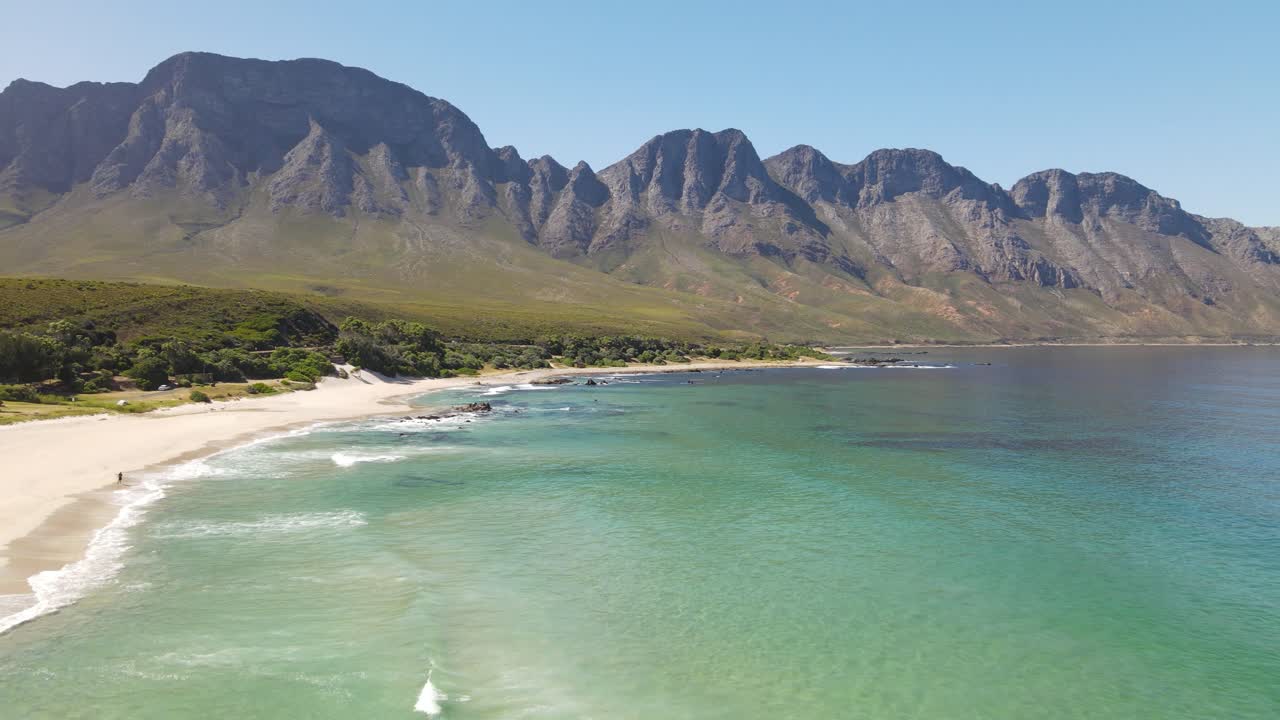 녹색의 역동적인 공중 촬영은 케이프 타운 근처의 배경에서 바다와 큰 산 형성을 진정시킬 수 있습니다.