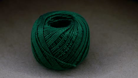 bola de lana de hilo verde en la mesa giratoria de papel de artesanía