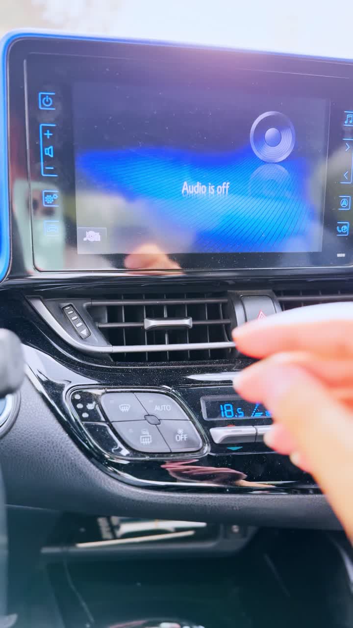 A person is adjusting the temperature in a car