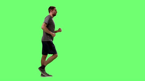 man in a t-shirt is sport walking on a mock-up green screen in the background.