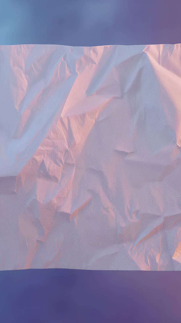 Vertical video: Shifting lights creating pink glow showing creases on crumpled paper on dark band