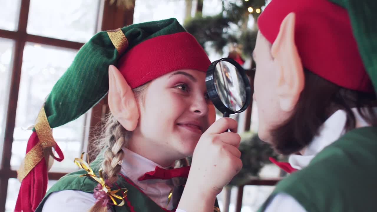 funny elves play with magnifying glass in santa claus new year residence