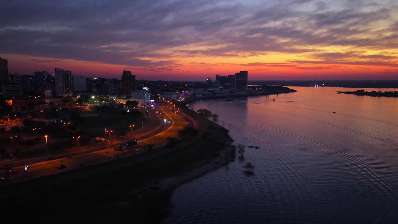 Asunción city skyline with illuminated José Asunción Flores Avenue beside the Costanera waterfront near the Paraguay River. Drone Aerial