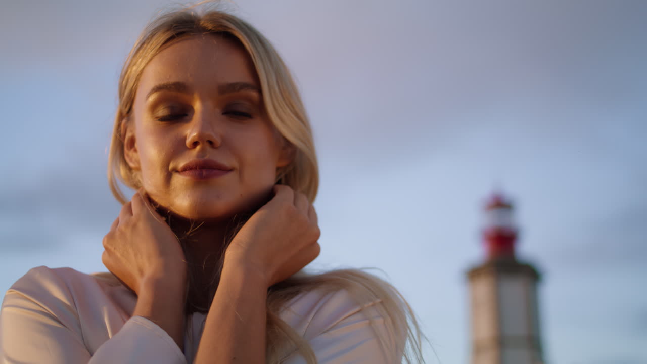 Ritratto verticale di donna sensuale in posa al tramonto. Modella rilassata che si sistema l'acconciatura.
