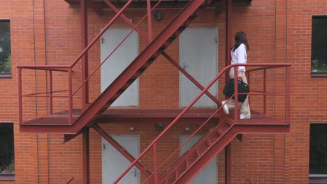 businesswoman climbing up the stairs of a business centre. elegant woman in formal wear with briefcase walking up on stair. worker commute to work in office. concept of morning and successful career