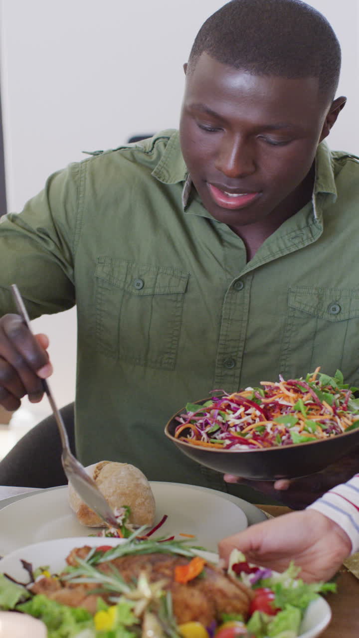 video vertical de un hombre afroamericano cenando con amigos