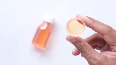 jarabe de medicamento en vaso dosificador