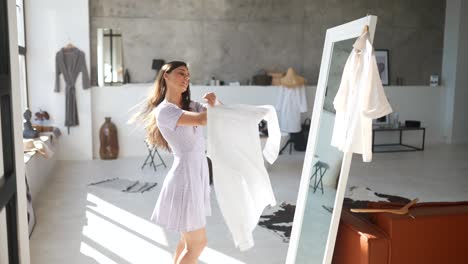 woman trying on clothes in front of a mirror