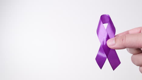 detail of a male hand holding a light purple ribbon on a white background