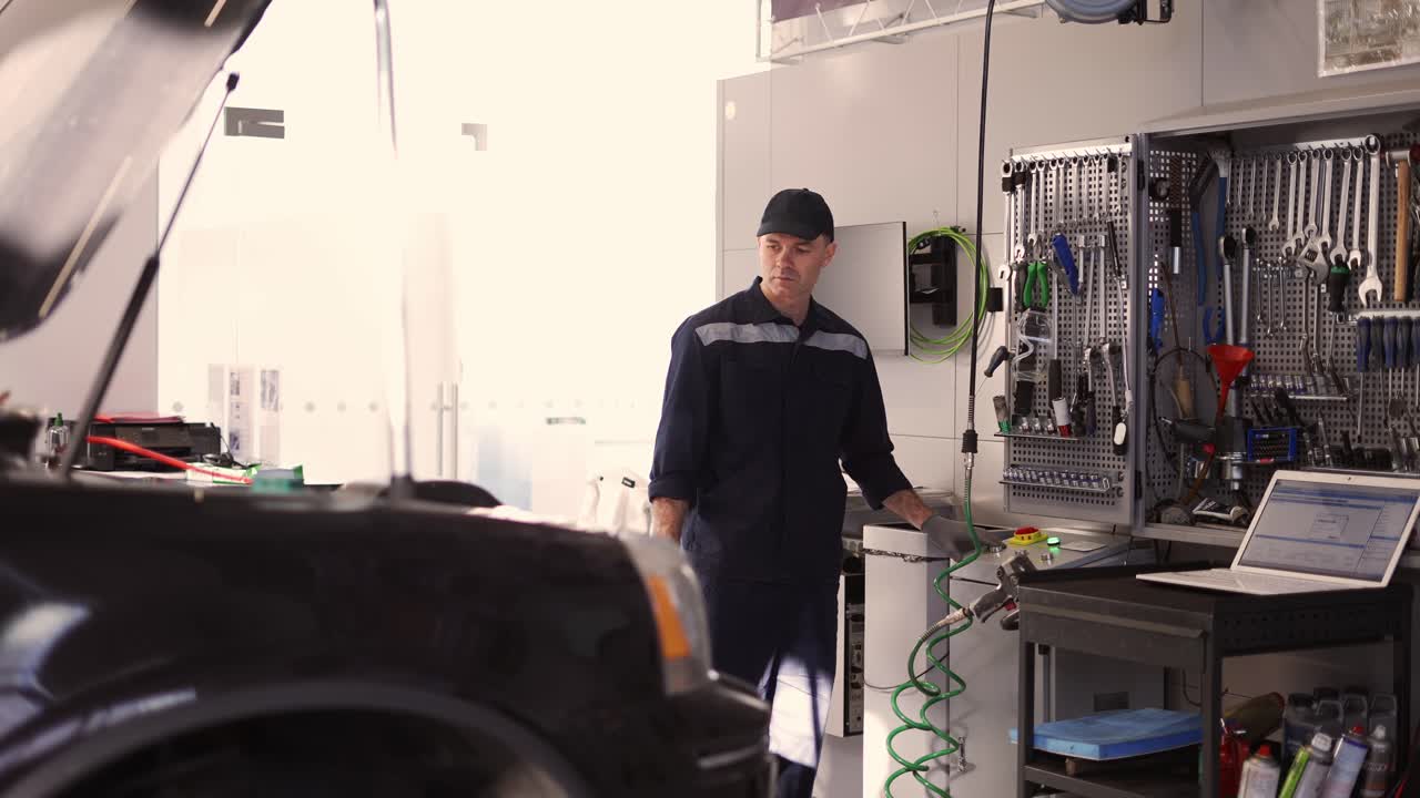 mecánico de automóviles profesional está levantando el automóvil automáticamente en el servicio de automóviles