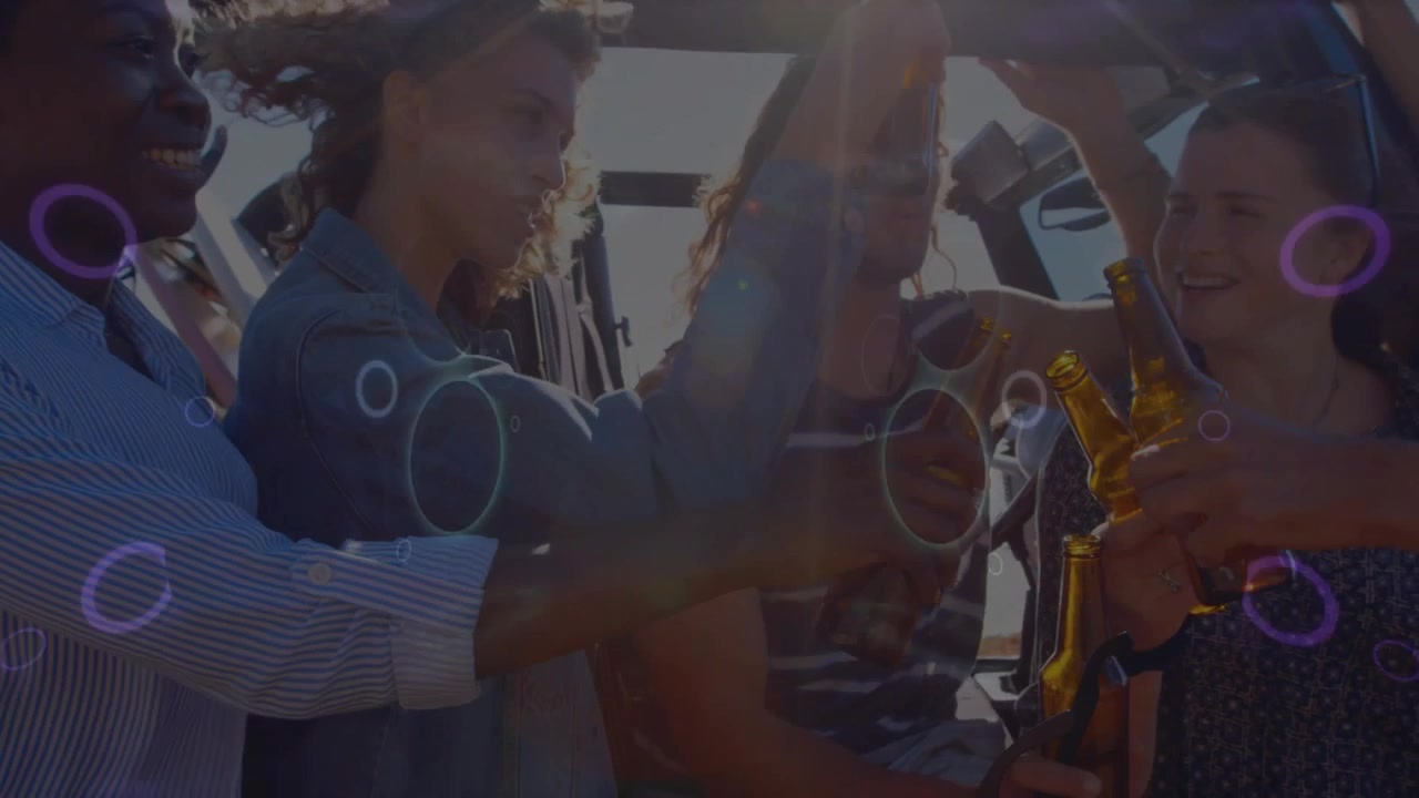 Vertical video: Raising amber bottles group of five in tanks toasting in open Jeep, neon overlay