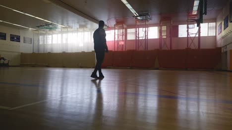 male walking onto court and looking around - strong athletic muscular black man standing on basketball court looking around in 4k
