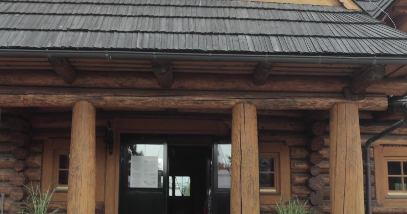 Fasad restoran kabin gunung pedesaan, terbuat dari balok kayu tua. Rekaman gimbal 4K yang dinamis.