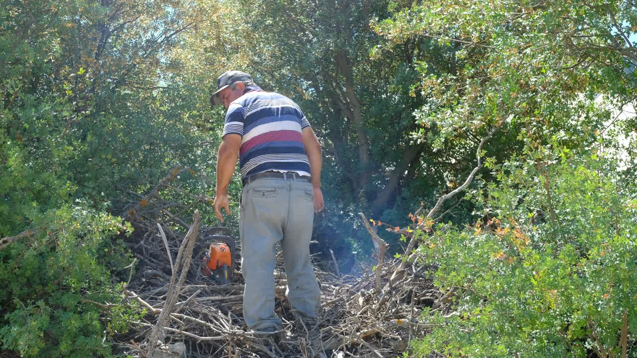 hombre cortando madera con un jardín de motosierra
