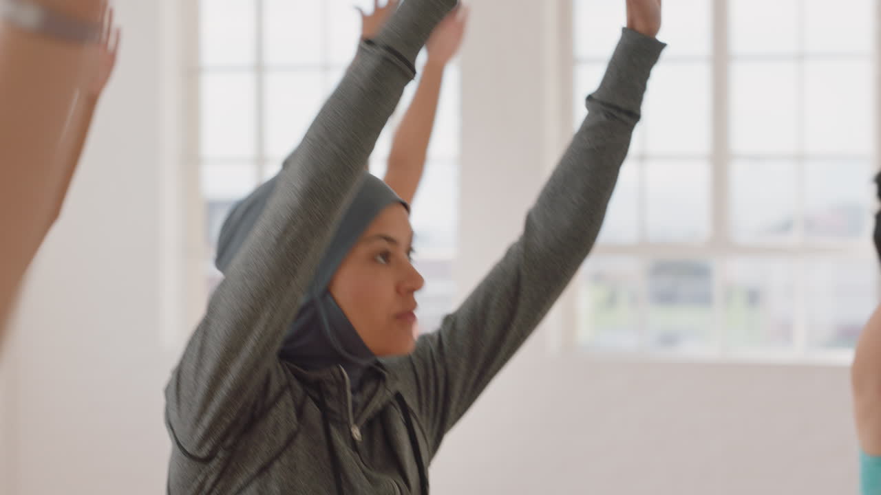 yoga class young muslim woman practicing warrior pose enjoying healthy lifestyle exercising with multi ethnic people in fitness studio