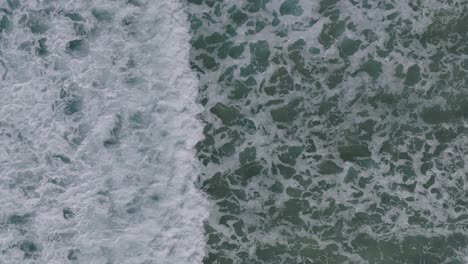 crashing foamy waves onto sea coast in razo beach during summertime in galicia, spain