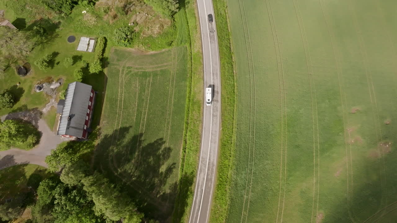 핀란드의 시골 도로에서 캠핑 밴을 따라 높은 각도 드론 촬영