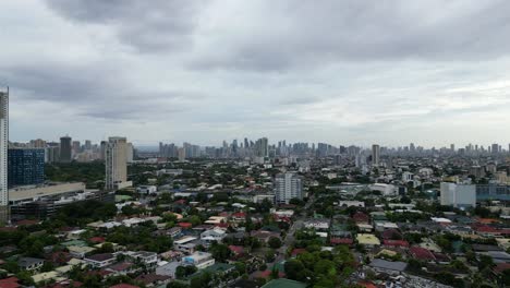 Flachbauten-In-Quezon-City-Mit-Riesiger-Skyline-Im-Hintergrund,-Luftaufnahme-Nach-Vorne