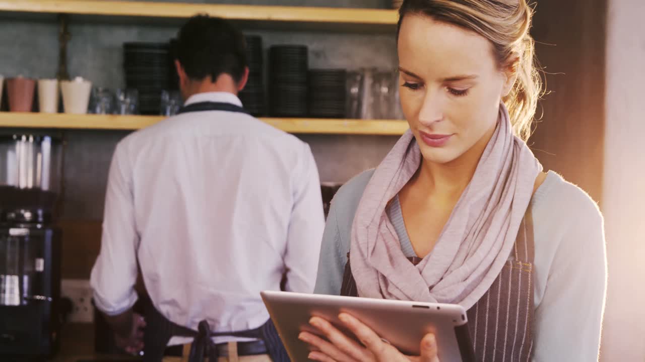 camarero y camarera mirando hacia atrás y hablando entre sí
