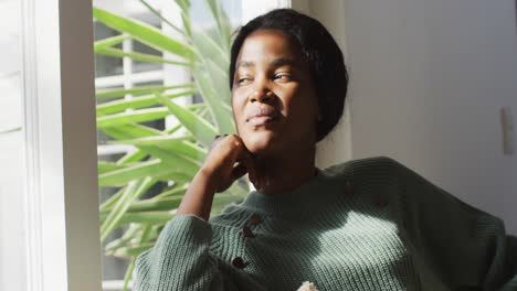 Video-of-relaxed-african-american-woman-looking-outside-window