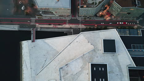 vista aérea de la ópera de oslo, personas caminando por el techo de la ópera, revelando edificios residenciales cercanos, paisaje urbano arquitectónico concepto de patrimonio