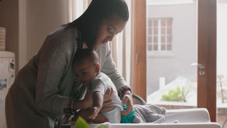 mother with baby dressing cute toddler caring for infant gentle mom enjoying motherhood nurturing her child at home