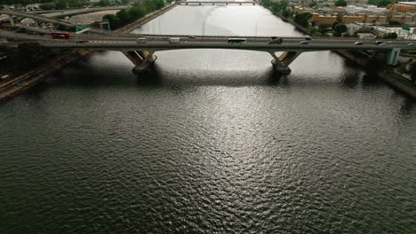 Toma-De-Vehículos-De-Tráfico-Conduciendo-Por-Una-Carretera-Sobre-Un-Amplio-Puente-Fluvial-En-China