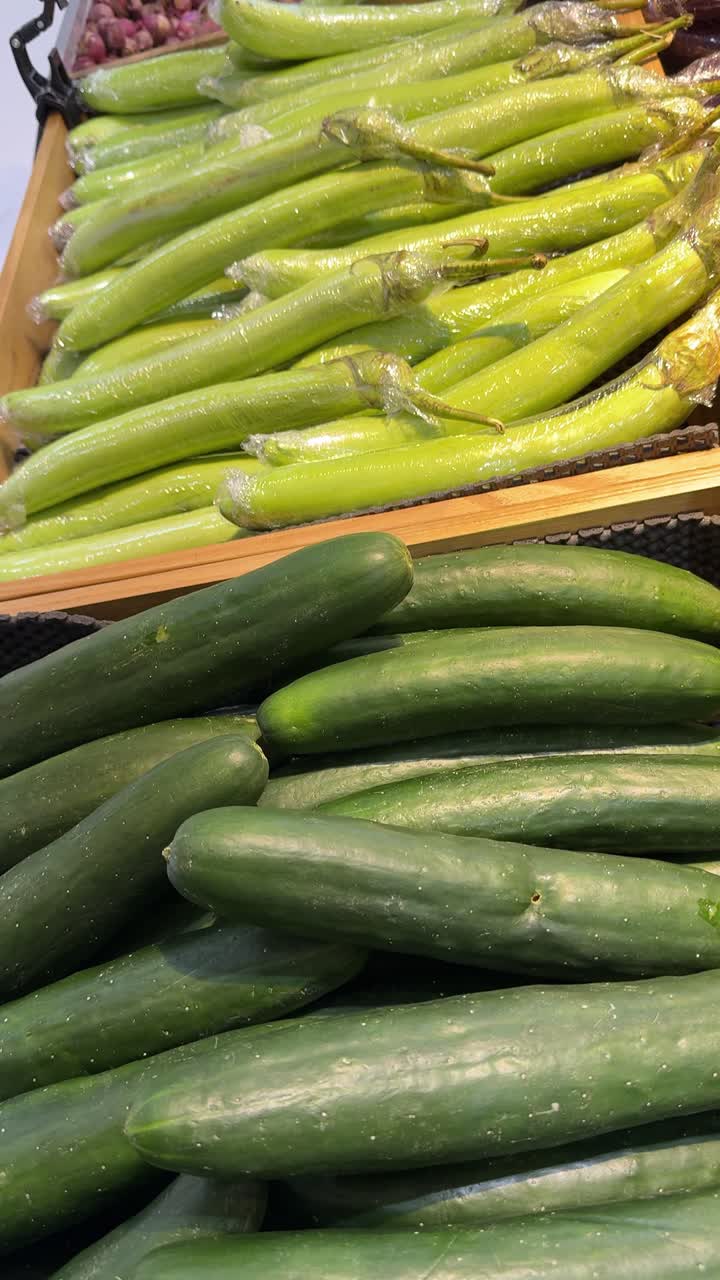 Cetrioli freschi e verdure verdi in esposizione in un negozio di alimentari