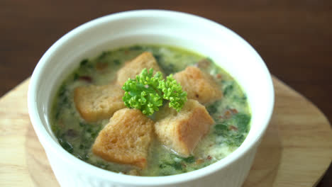 sopa de espinacas con pan en tazón blanco