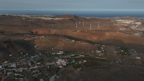 aerial perspective revealing roque aguayro mountain and wind turbines generating renewable energy during golden sunset in gran canaria landscape