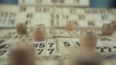 Macro-video-of-a-Bingo-board,-studio-lights,-120-fps,-slow-motion,-wooden-chip-digits,-Raw-footage,-lottery-desk-game,-card-numbers,-crane-zoom-in-smooth-movement