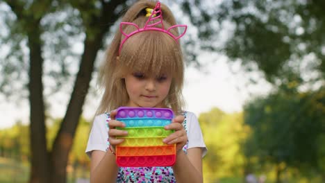 Female-child-girl-playing-push-pop-it-bubble-fidget-stress-anxiety-relief-squeeze-sensory-game-toys