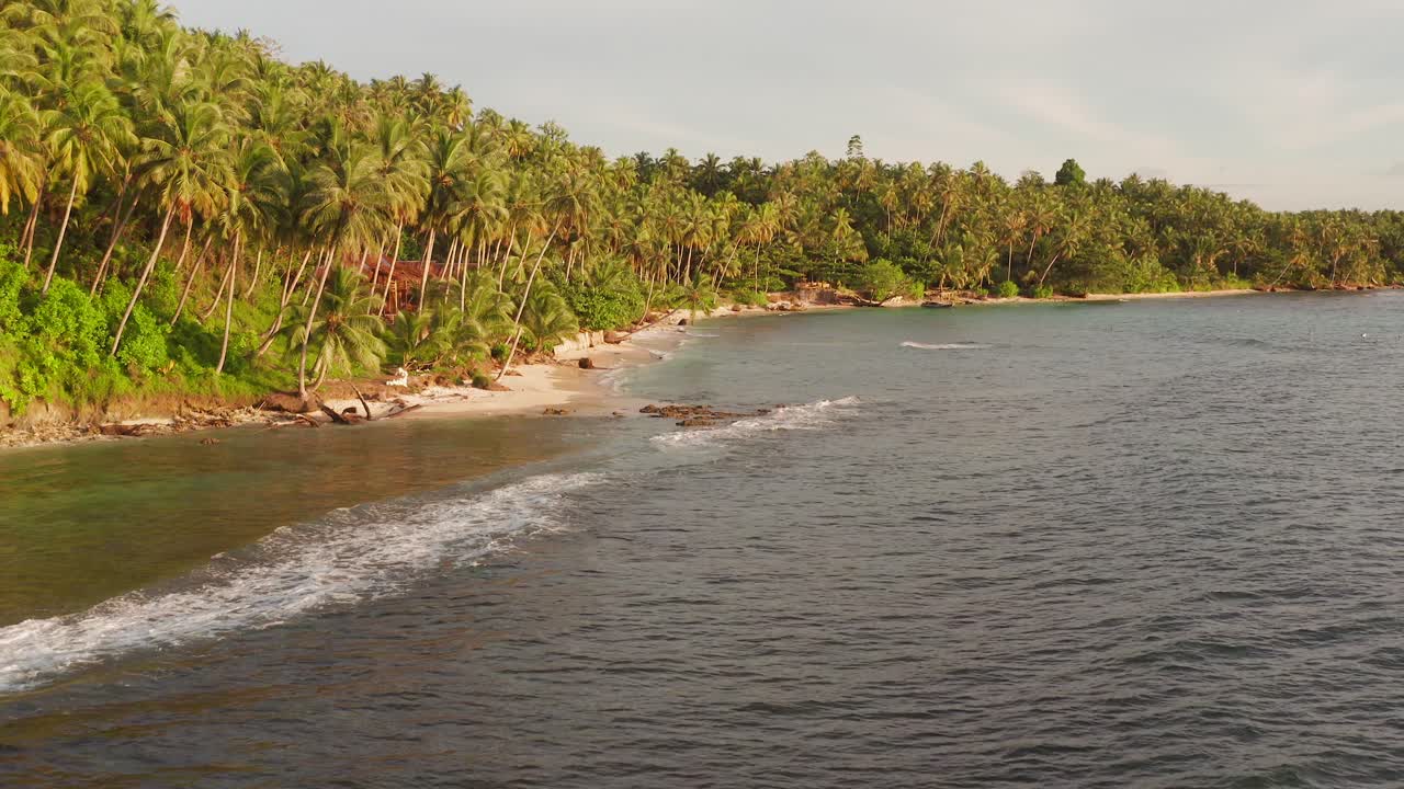 Revealing shot of a bay with a beautiful tropical beach and surf resorts in the Mentawai. Drone shot
