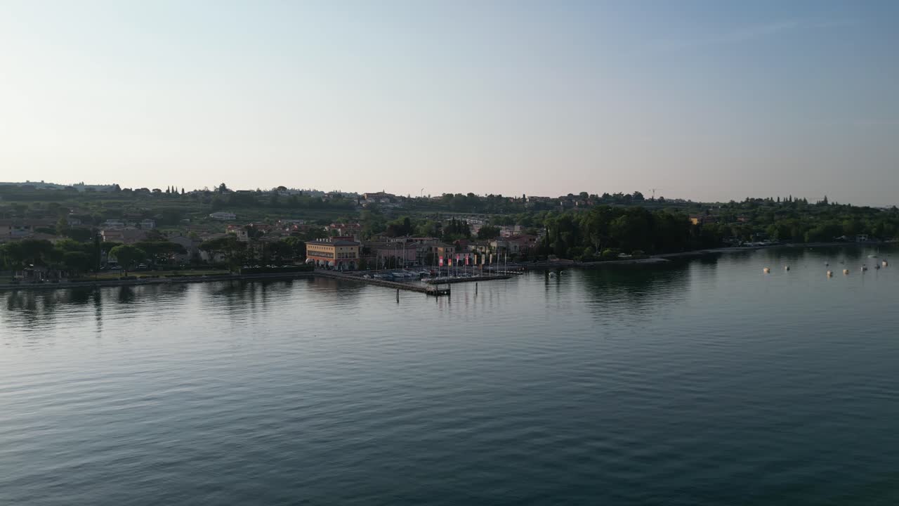 перелет над озером гарда с прибрежным городом и отелями в цисано, провинция верона, италия