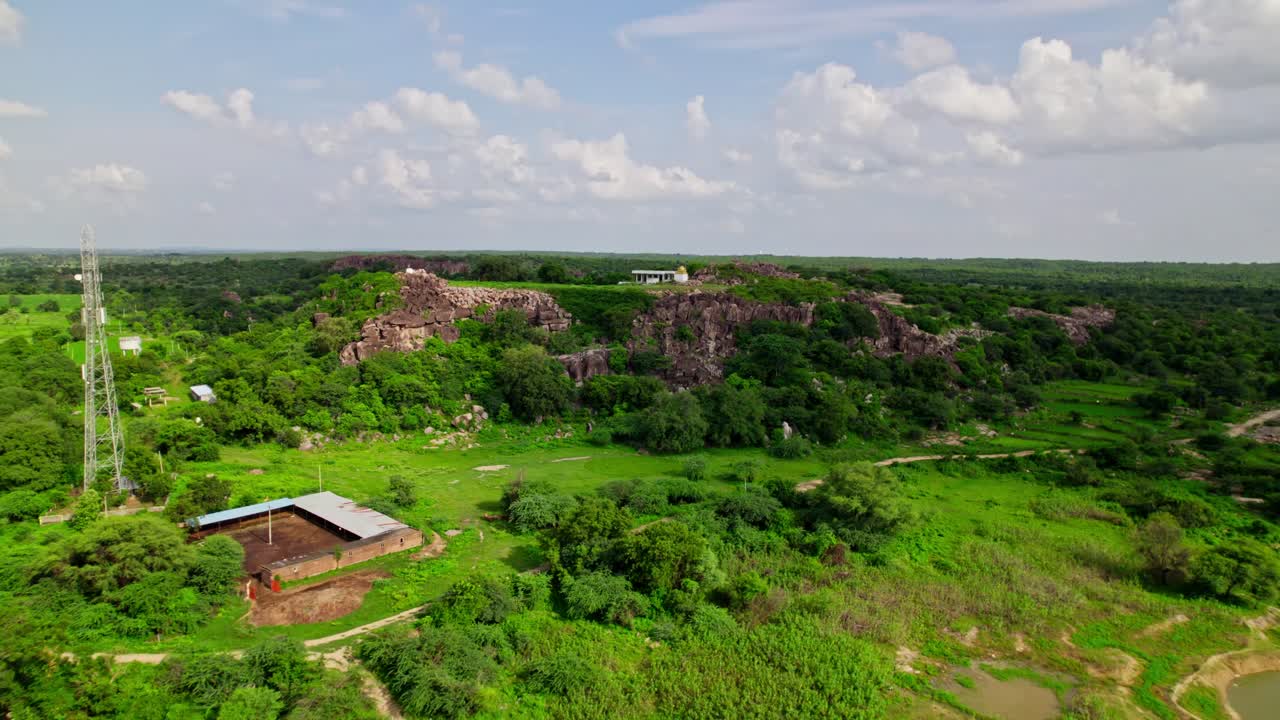 aerial view of Sri rama Temple in the hill top with greenery, sky and clouds at yelupugonda village, Tekmal, telangana, india. day time, push in, drone shot, 4k.