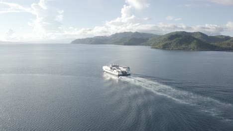 local passenger fastcat ferry boat sailing and leaving wake at the blue ocean near the port in liloan, southern leyte, philippines