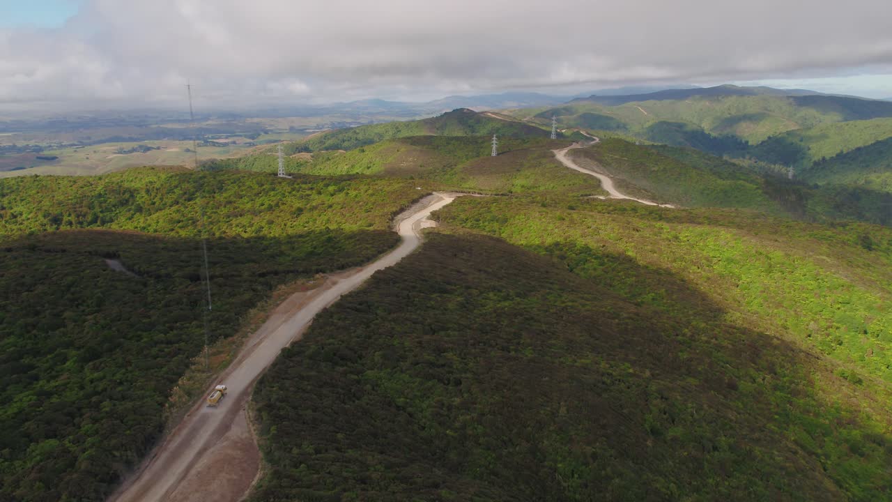 un camión cisterna humedece una carretera en construcción durante el verano