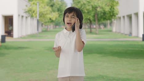 angry indian boy talking on call in park