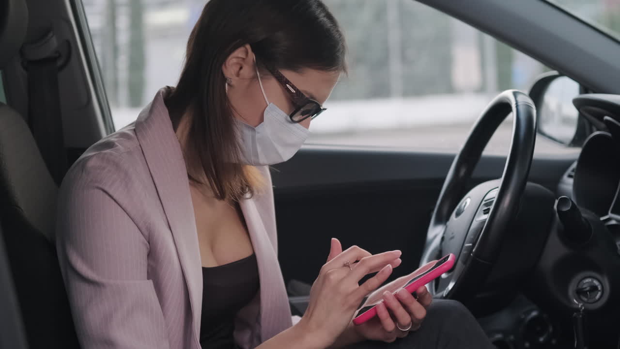 mujer usando el teléfono mientras viaja en un coche, usando una máscara